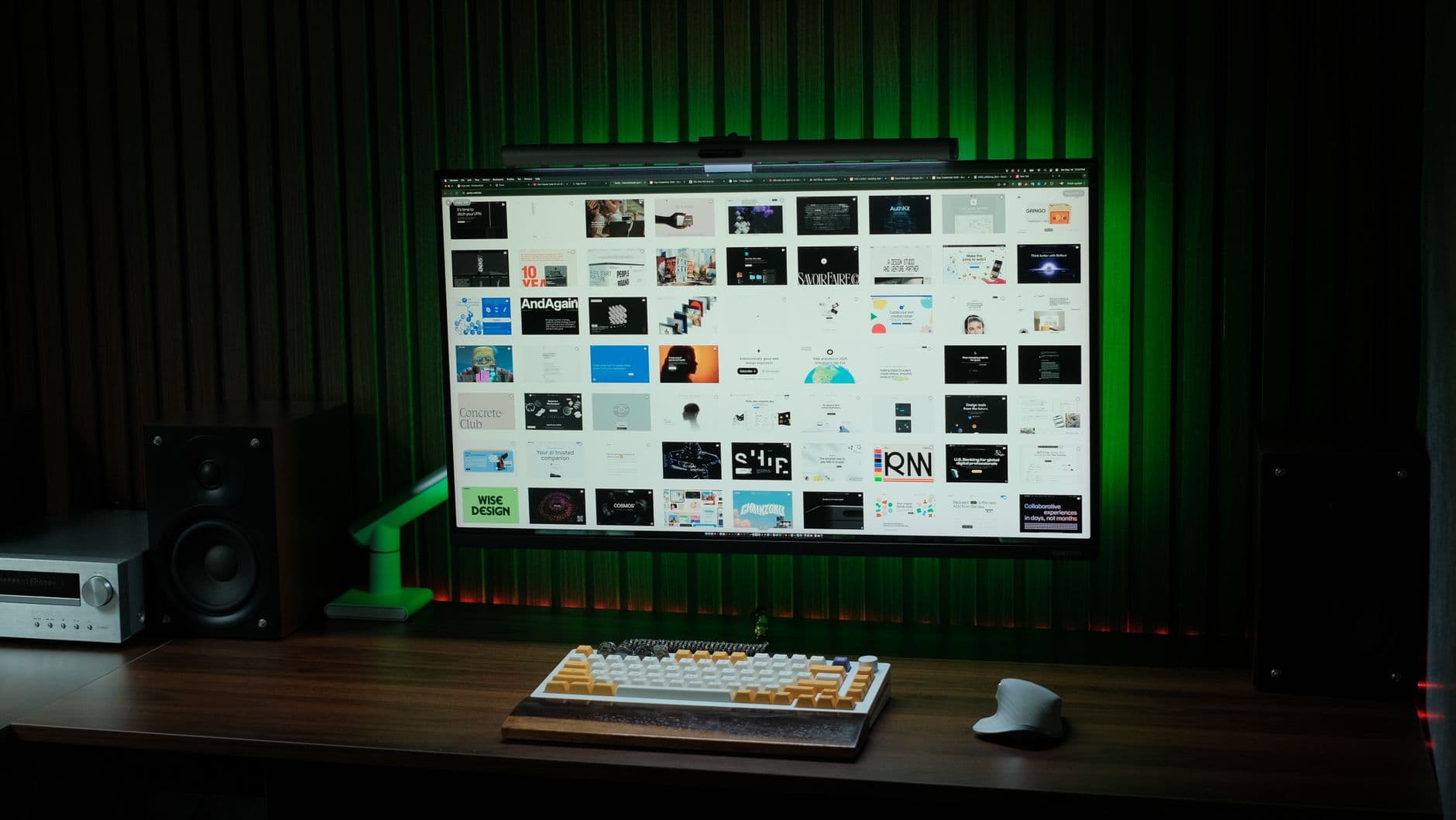 Sleek computer setup featuring a monitor, keyboard, and speakers in a dimly lit room.
